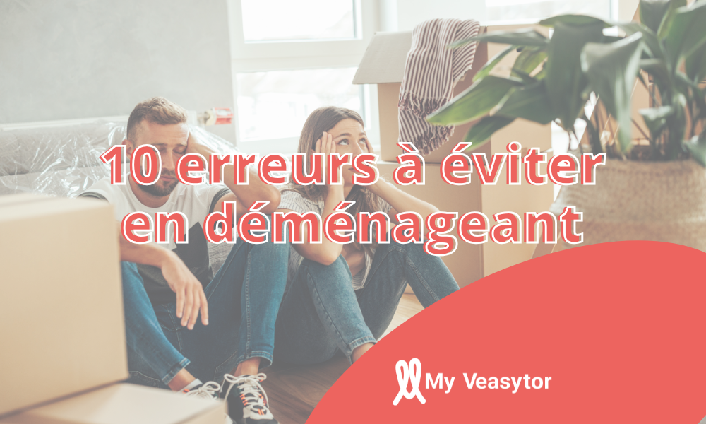 Couple fatigué assis au milieu de cartons de déménagement, illustrant le stress et les erreurs fréquentes lors d’un déménagement.